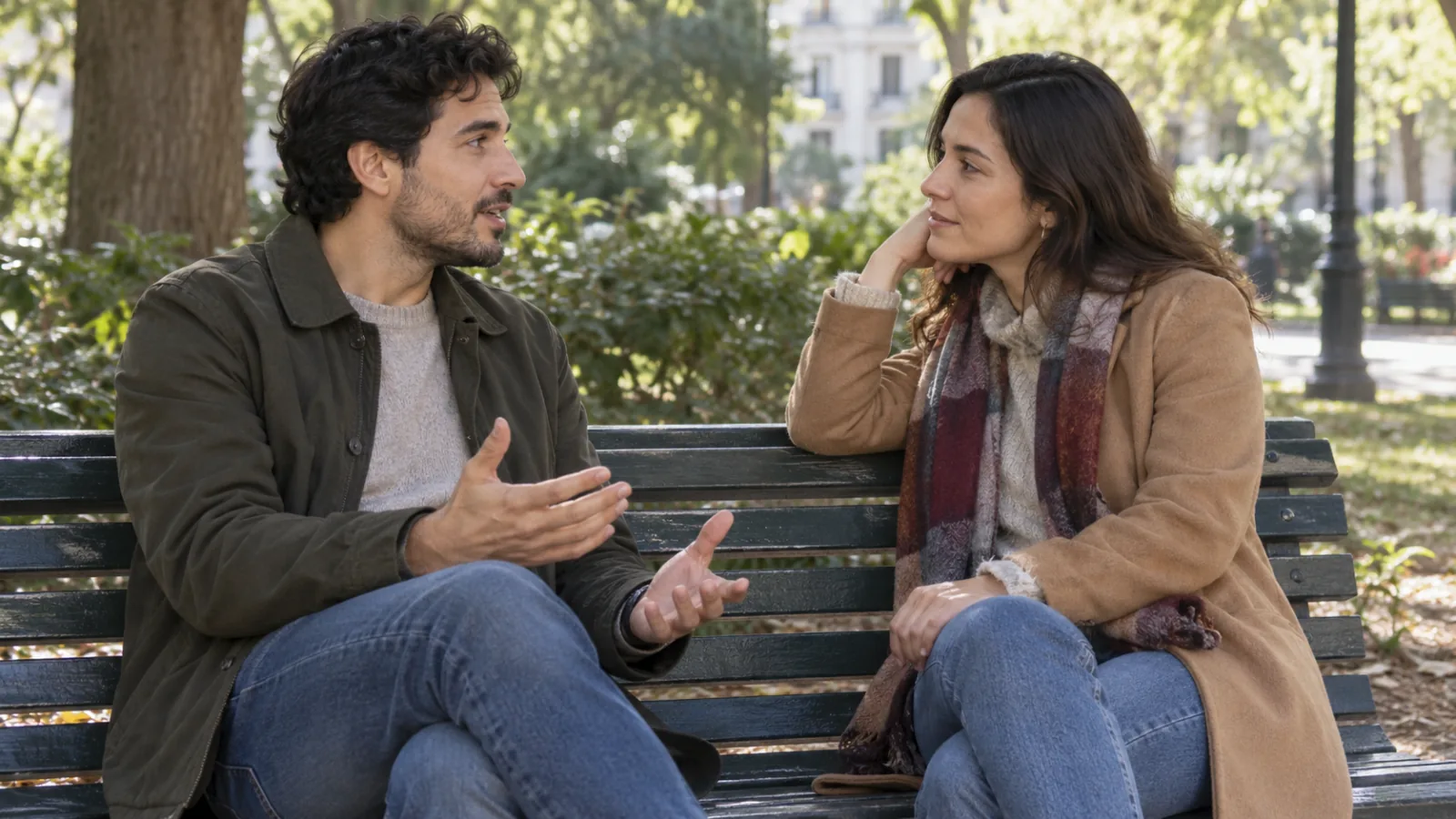 Un uomo e una donna parlano seduti su una panchina in un parco